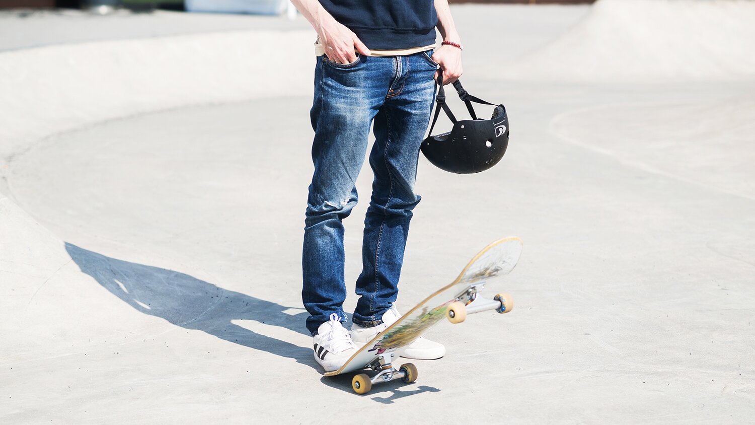 Man holding a skateboard under his foot.